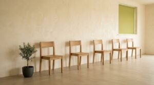 明るい部屋にゆとりをもって並ぶ木の椅子｜インビザライン ファーストとフェーズ2の考え方